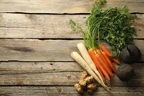 Different root vegetables on wooden table, flat lay. Space for text Stock Photos