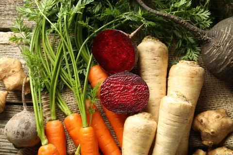 Different root vegetables on wooden table, flat lay Stock Photos