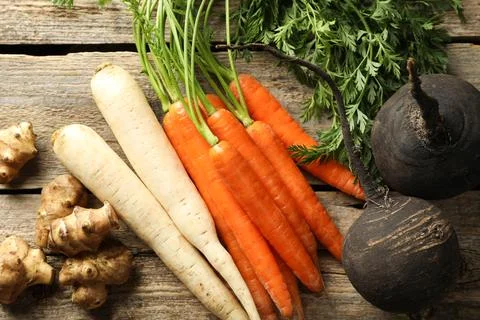 Different root vegetables on wooden table, flat lay Stock Photos