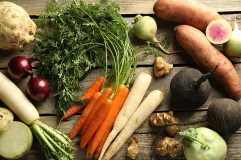 Different root vegetables on wooden table, flat lay Stock Photos