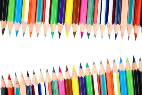 Different rows of different color pencil crayons placed on a white background Foto stock