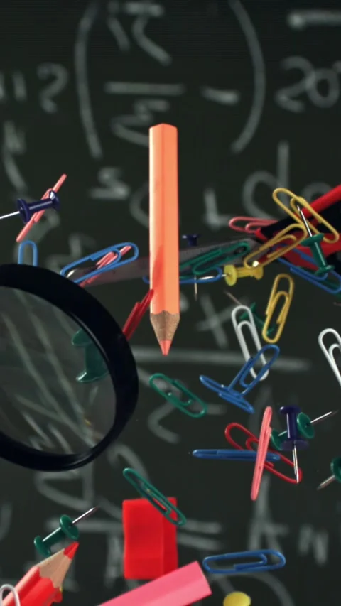 Different school objects fly and fall against the background of the blackboard Stock Footage 335375120
