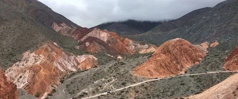 Different shades of red in the mountains with cyclists at the bottom Video stock 90665585