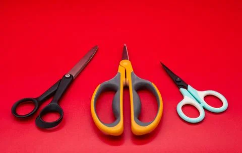 Different shape scissors isolated on red background Stock Photos