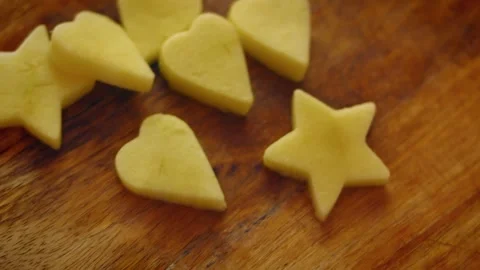 Different shaped cookie cutters are used on apple slices Stock Footage 331634426