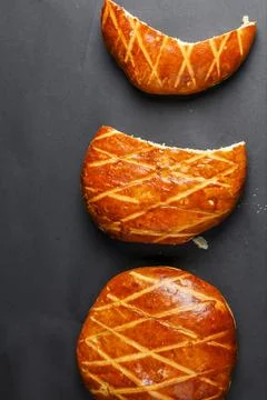 Different shapes of freshly baked bread on a dark surface Stock Photos