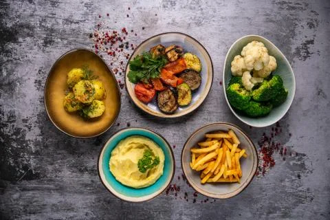 Different side dishes on a grey background, French fries, mashed potatoes, ri Foto stock