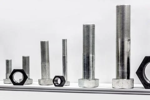 Different size bolts with nuts are screwed as a sample Stock Photos