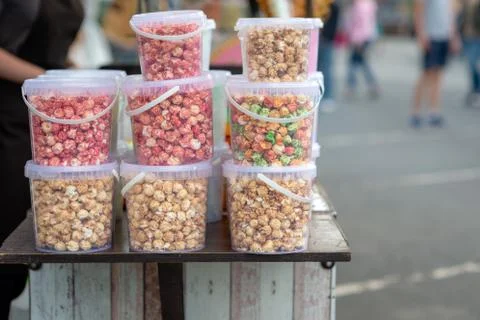 Different size buckets with colored popcorn. Stock Photos