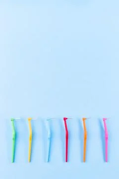 Different size interdental brush angles on blue background, vertical, copy space 스톡 사진