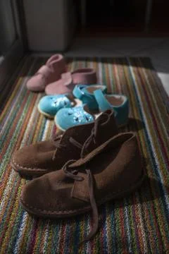 Different size shoes lined up on doormat Stock Photos