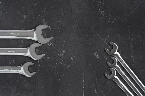 Different size wrenches on black background with copy space, steel hand worki Stock Photos