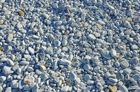 Different sized oval and round marble pebbles on the coast of the Ligurian Se Foto stock