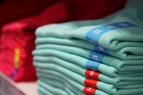 Different sizes of clothes in the shop Stock Photos