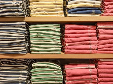 Different sizes of clothes in the shop. Stock Photos