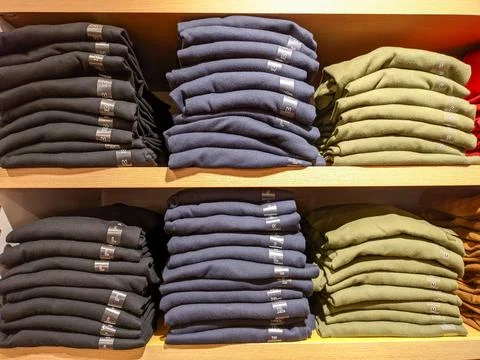 Different sizes of clothes in the shop. Stock Photos