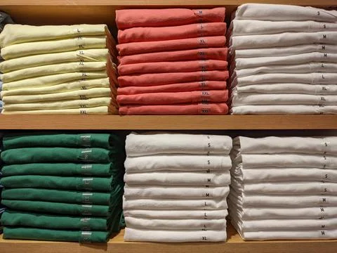 Different sizes of clothes in the shop. Stock Photos