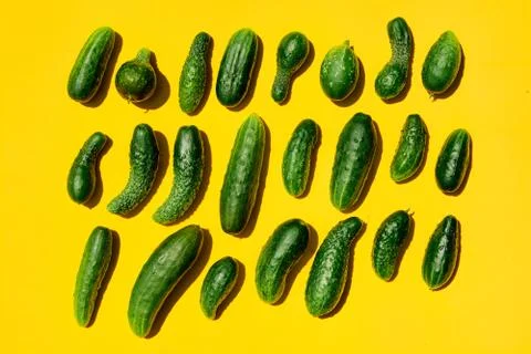 Different sizes forms cucumbers pattern on a light yellow background. Copy sp Stockfoto's