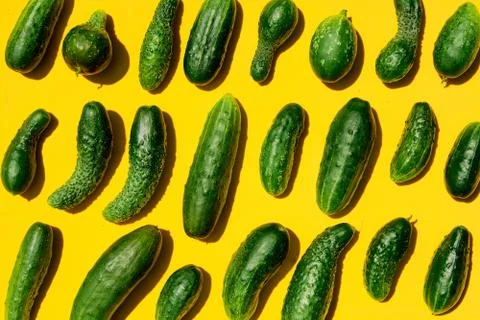 Different sizes forms cucumbers pattern on a light yellow background. Copy sp Stockfoto's