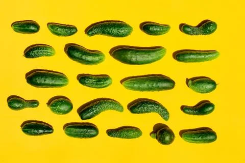 Different sizes forms cucumbers pattern on a light yellow background. Copy sp Stockfoto's