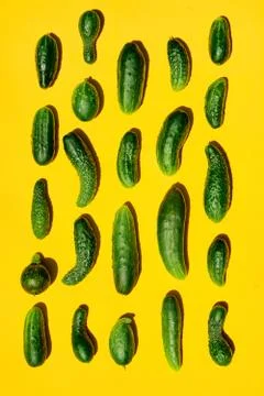 Different sizes forms cucumbers pattern on a light yellow background. Copy sp Stockfoto's