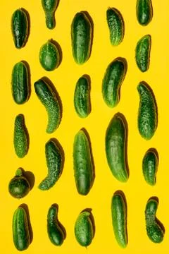 Different sizes forms cucumbers pattern on a light yellow background. Copy sp Stockfoto's