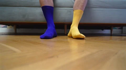 Different socks in legs. Mismatched multicolored socks on feet man. Stock Footage 308490265
