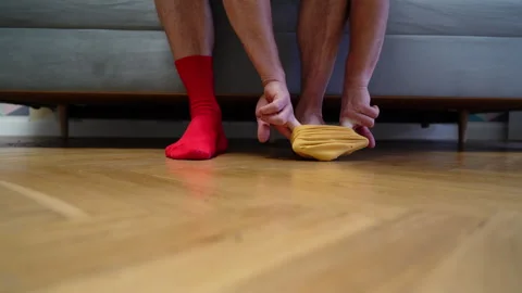 Different socks in legs. Mismatched multicolored socks on feet man Stock Footage 308922809