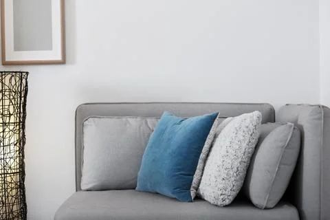 Different soft pillows on sofa in room. Interior element Stock Photos