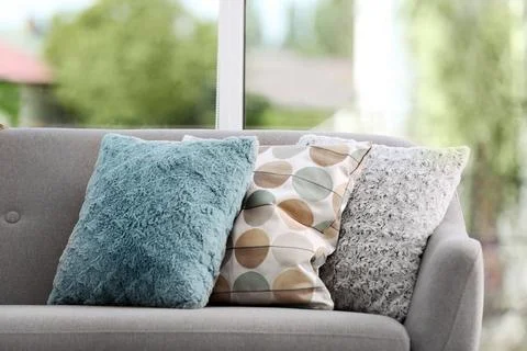 Different soft pillows on sofa in room. Interior element Stock Photos