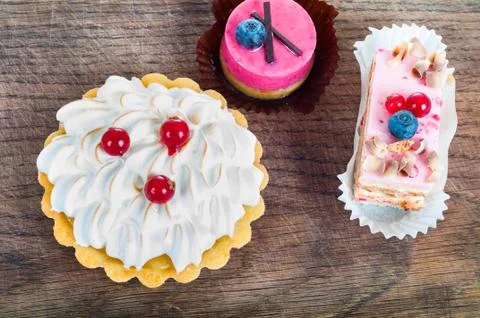 Different sort of beautiful pastry, small colorful sweet cakes on Stock Photos