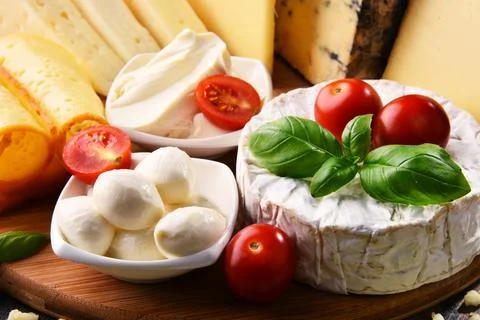 Different sorts of cheese on kitchen table. Stock Photos