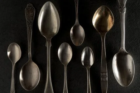Different spoons on a black stone close-up Stock Photos