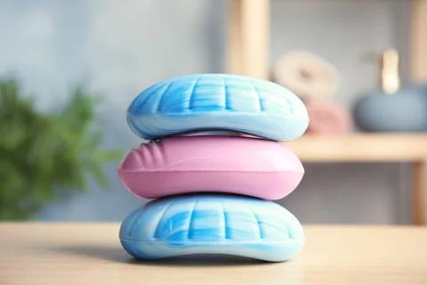 Different stacked soap bars on table in bathroom Stock Photos
