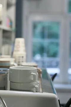 Different stacks of coffee cups in the background window Stock Photos