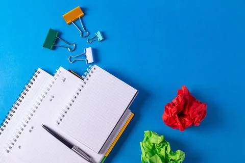 Different stationary items and notebooks on the blue background. Stock Photos