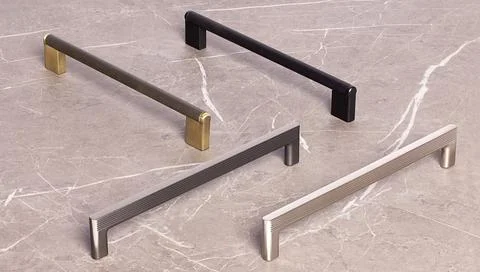 Different styles of cabinet handles displayed on a stone surface showing va.. Photos