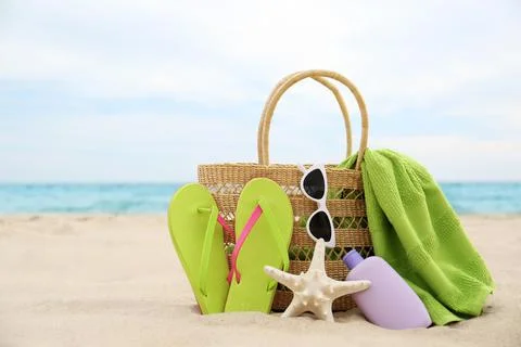Different stylish beach objects and starfish on sand near sea 스톡 사진