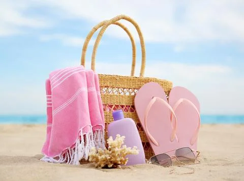 Different stylish beach objects and coral on sand near sea Stock Photos