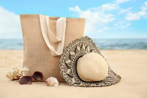 Different stylish beach objects, coral and seashell on sand near sea Stock Photos