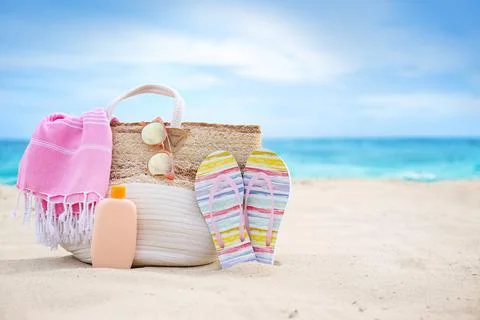 Different stylish beach objects on sand near sea. Space for text Stock-Fotos