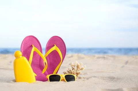 Different stylish beach objects on sand near sea. Space for text Stock-Fotos