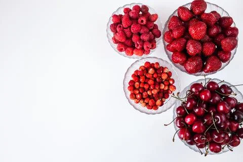 Different summer berries in plates Stock Photos