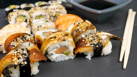 Different sushi rolls on black stone plate Stock Footage 95280805