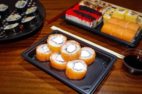 Different sushi rolls on the table in plates with sauces. Foto stock