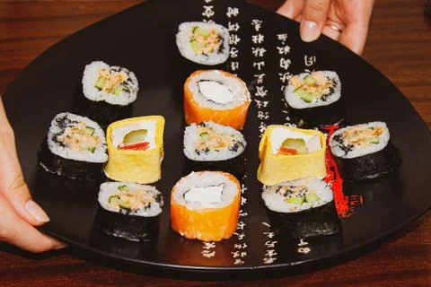 Different sushi rolls on the table in plates with sauces. Foto stock