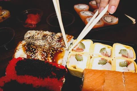 Different sushi rolls on the table in plates with sauces. Stock Photos