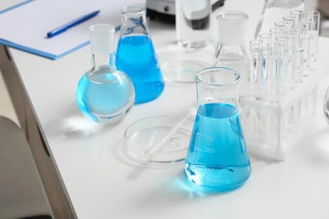 Different test tubes and flasks of water samples on table in research laborat Stock Photos