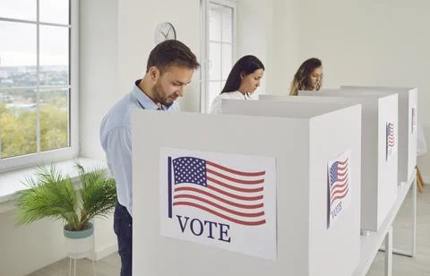 Different thoughtful people casting their votes inside voting booths during Stock Photos