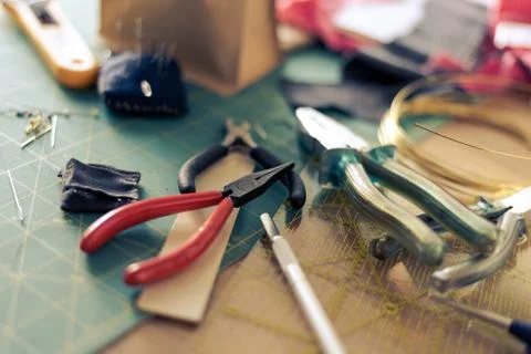 Different tongs for handiwork lying unorderly on table Stock Photos